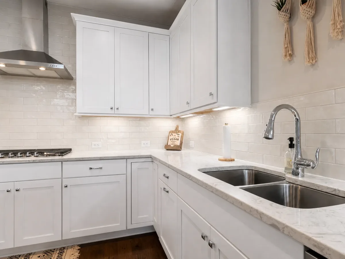 Warm white painted kitchen cabinets in a real kitchen setting.